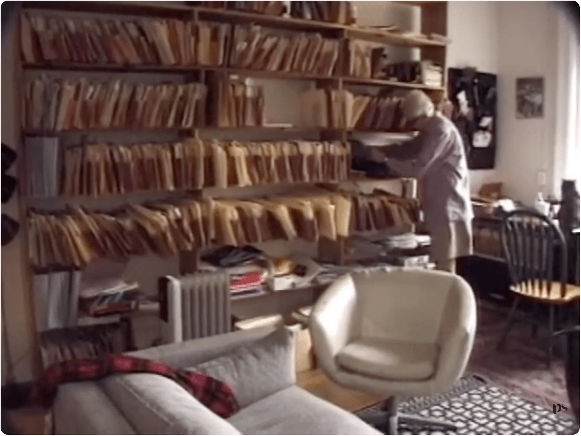 Henry in his apartment with filing system